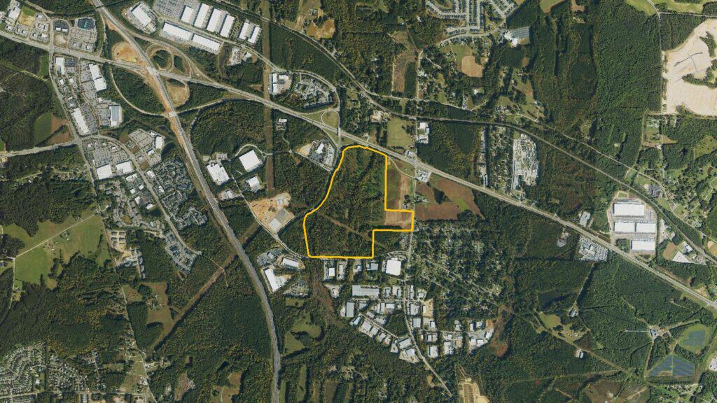 Wider aerial view of the Project Cougar site in Garner, North Carolina, outlined in yellow, with the surrounding highways and industrial buildings